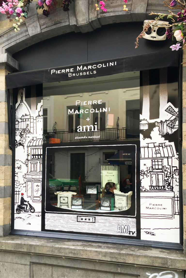 Vitrine d'un magasin de Pierre Marcolini décorée avec des accessoires et de la vitrophanie.